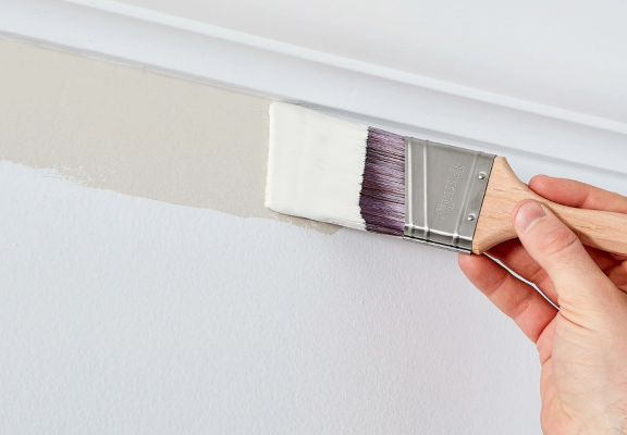 Brushing colored paint next to a ceiling